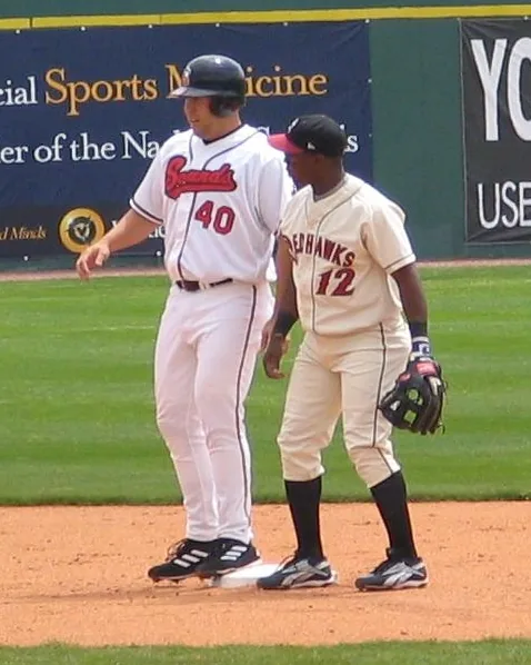 Brad Nelson, a first baseman for the minor league Nashville Sounds, being held at second base by Esteban Germán in a game at Herschel Greer 