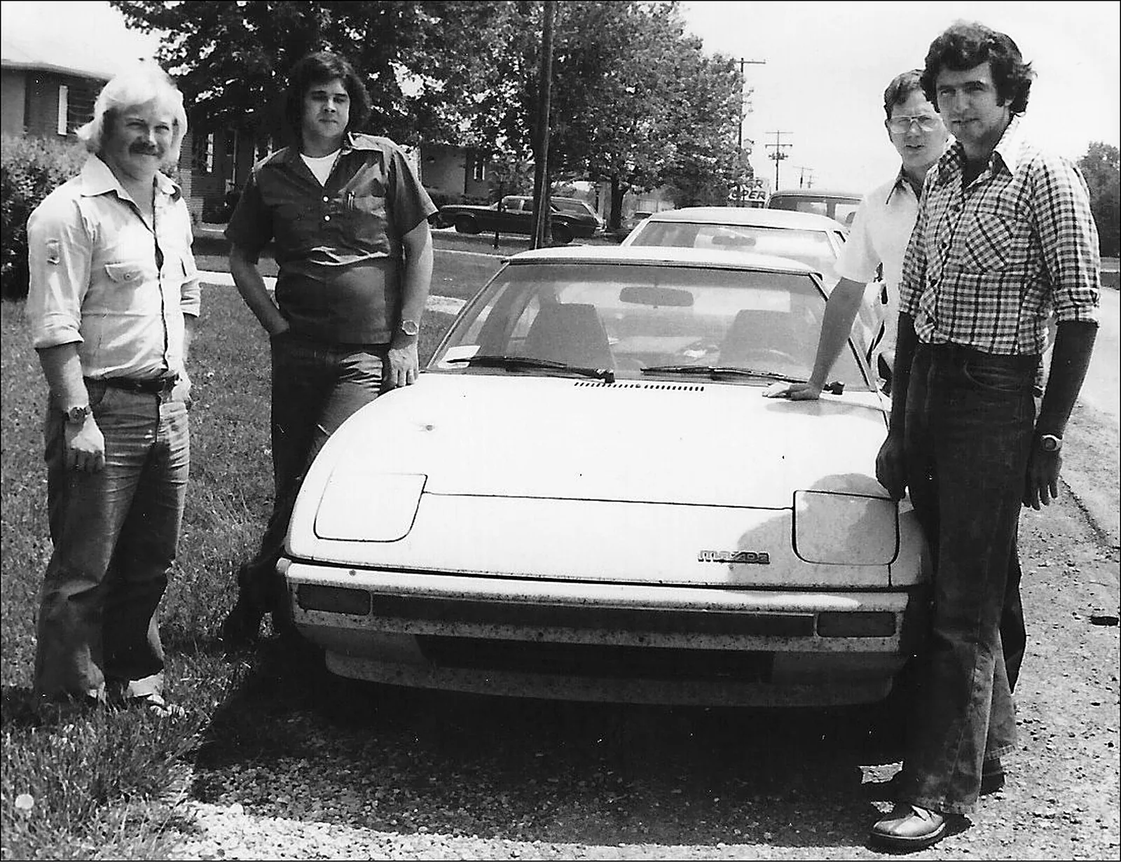 September 1978: New Zealanders Rod Millen (far R) and mechanic Murray Butt (far L) drove their just-on-the-market Mazda RX7 from California 